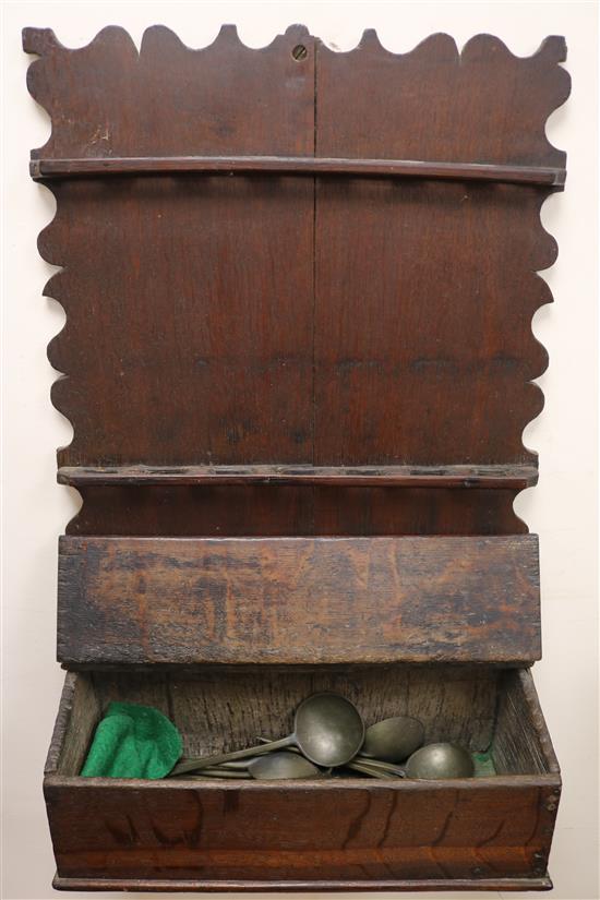 An 18th century oak candlebox and a spoon rack housing eight pewter spoons